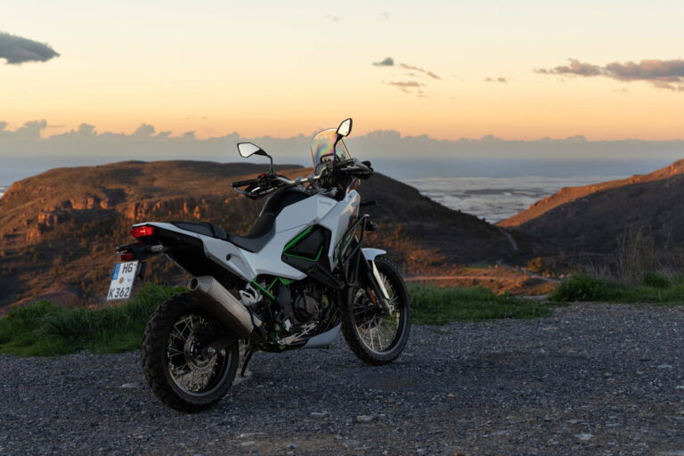 Motocicleta em uma estrada sinuosa nas montanhas dos Pireneus na Espanha, ao pôr do sol, destacando a beleza das melhores viagens de moto na Europa.