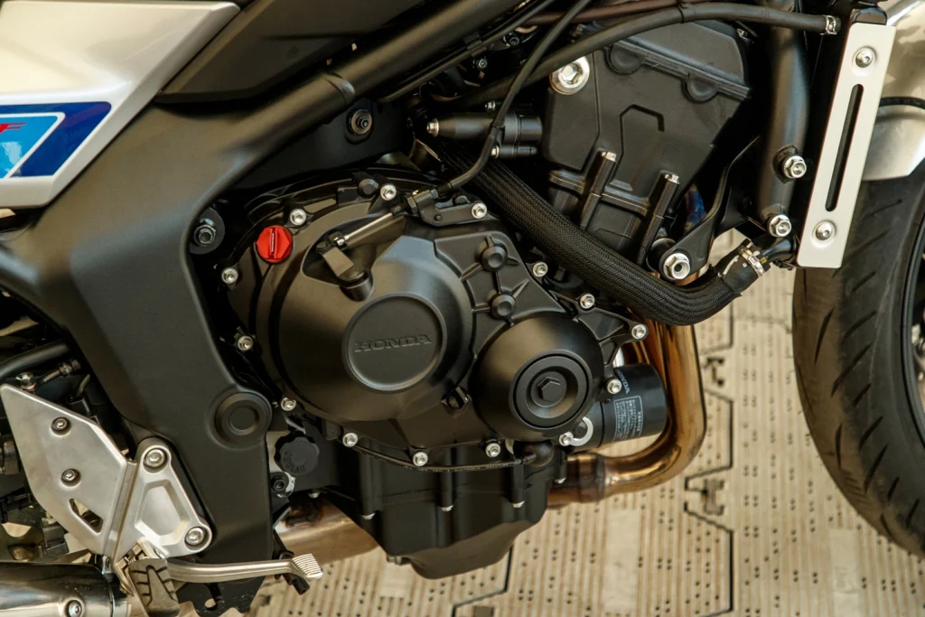 Honda CB1000F em movimento, exibindo seu design neo-retro com farol redondo e linhas modernas, destacando a fusão de clássico e tecnologia.