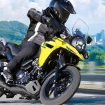 Motocicleta Suzuki V-Strom 250 em cenário de aventura, destacando seu design robusto e aptidão para viagens.