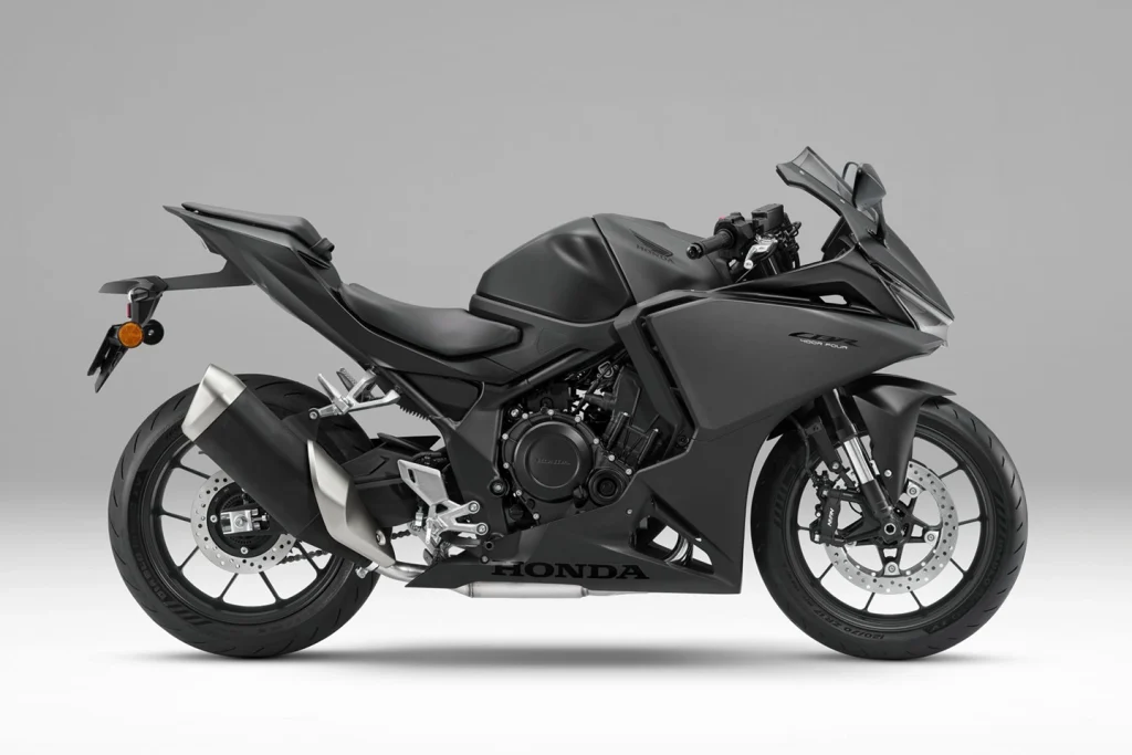 Detalhe da nova Honda CBR400R Four E-Clutch com seu motor e o sistema de embreagem eletrônica visível, destacando a inovação da marca.