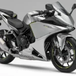 Detalhe da nova Honda CBR400R Four E-Clutch com seu motor e o sistema de embreagem eletrônica visível, destacando a inovação da marca.