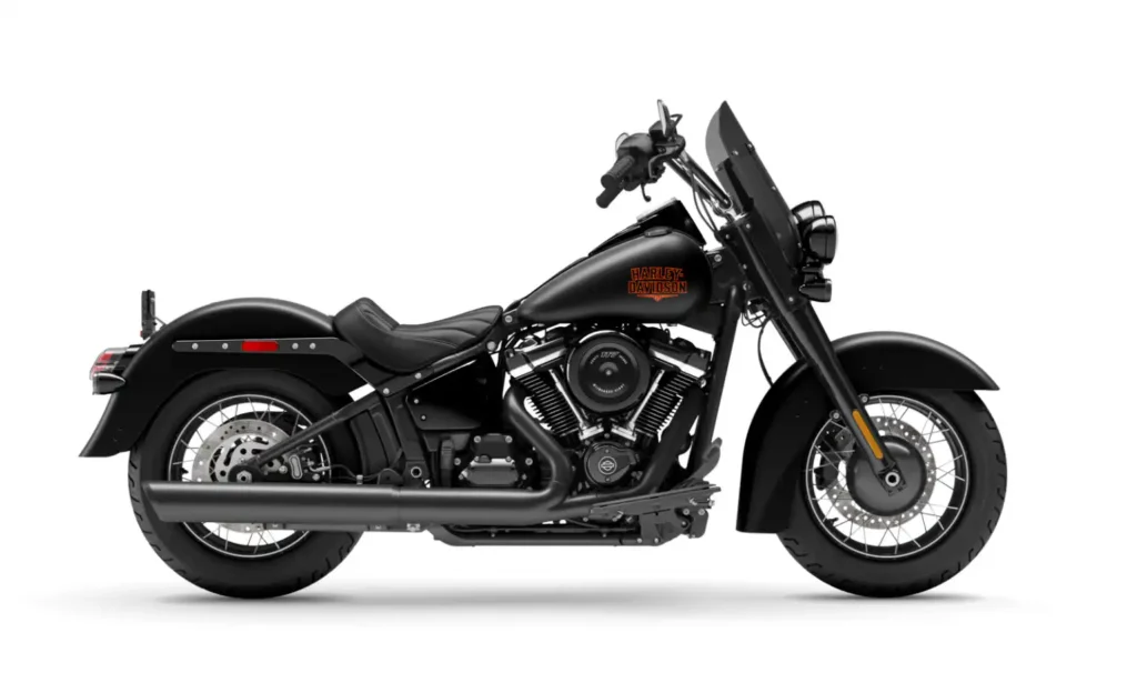 Renderização conceitual de uma motocicleta Harley-Davidson Deadwood estilo bobber retro em uma estrada sinuosa, com farol único e banco solo, em tons escuros e cromados.