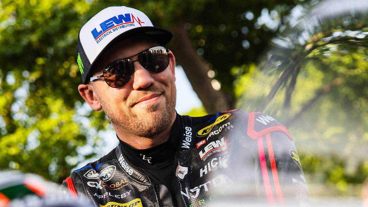Peter Hickman se preparando para pilotar a lendária moto de corrida Norton Rotary na Snaefell Mountain Course do Classic TT, destacando o motor Wankel e seu design clássico de corrida.