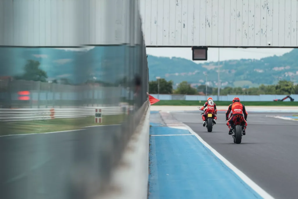 Ducati Panigale V4 R em pista durante o evento DRE Racetrack, com um piloto em inclinação máxima, demonstrando a pilotagem esportiva e a performance da motocicleta.