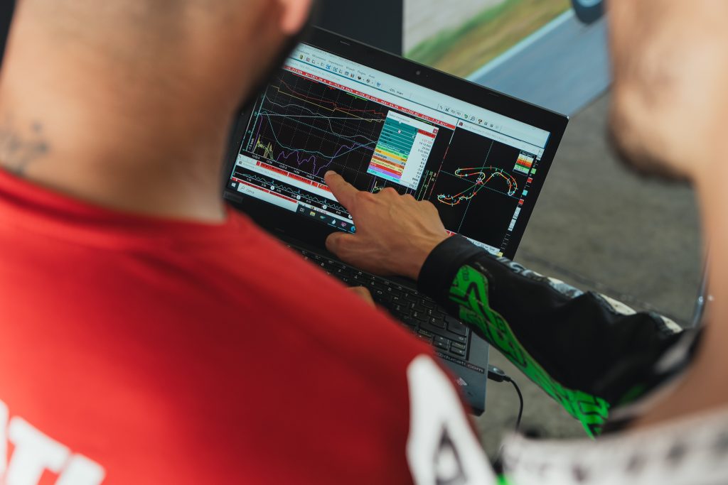 Ducati Panigale V4 R em pista durante o evento DRE Racetrack, com um piloto em inclinação máxima, demonstrando a pilotagem esportiva e a performance da motocicleta.