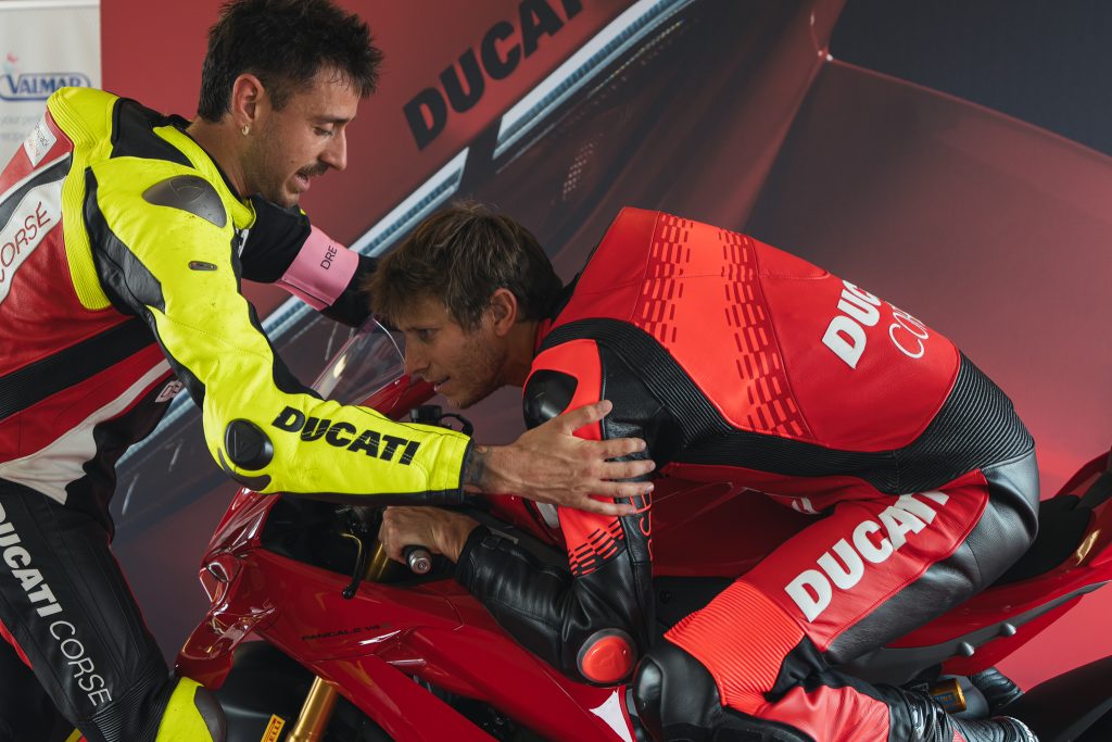 Ducati Panigale V4 R em pista durante o evento DRE Racetrack, com um piloto em inclinação máxima, demonstrando a pilotagem esportiva e a performance da motocicleta.