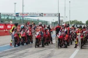 Ducati Panigale V4 R em pista durante o evento DRE Racetrack, com um piloto em inclinação máxima, demonstrando a pilotagem esportiva e a performance da motocicleta.