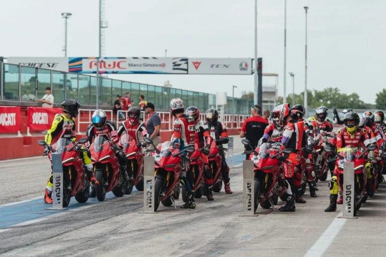 Ducati Panigale V4 R em pista durante o evento DRE Racetrack, com um piloto em inclinação máxima, demonstrando a pilotagem esportiva e a performance da motocicleta.