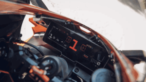 Painel de uma motocicleta KTM moderna, exibindo informações digitais e um guidão em destaque, simbolizando a inovação e o sucesso da marca no mercado.