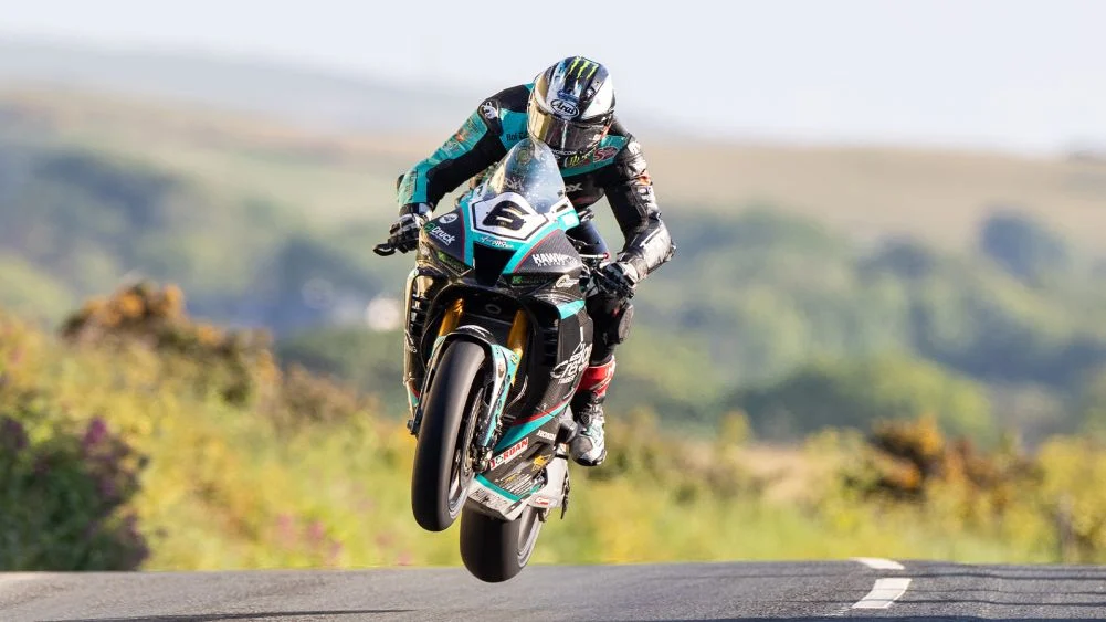 Michael Dunlop em sua moto de corrida em alta velocidade durante o Isle of Man TT, demonstrando sua perícia nas desafiadoras estradas.