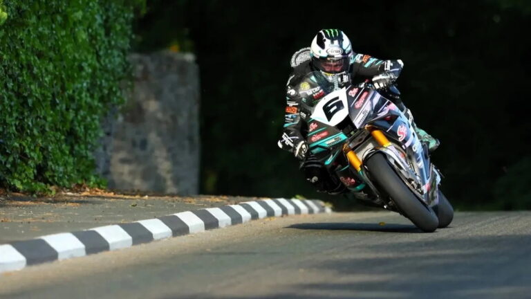 Michael Dunlop em sua moto de corrida em alta velocidade durante o Isle of Man TT, demonstrando sua perícia nas desafiadoras estradas.