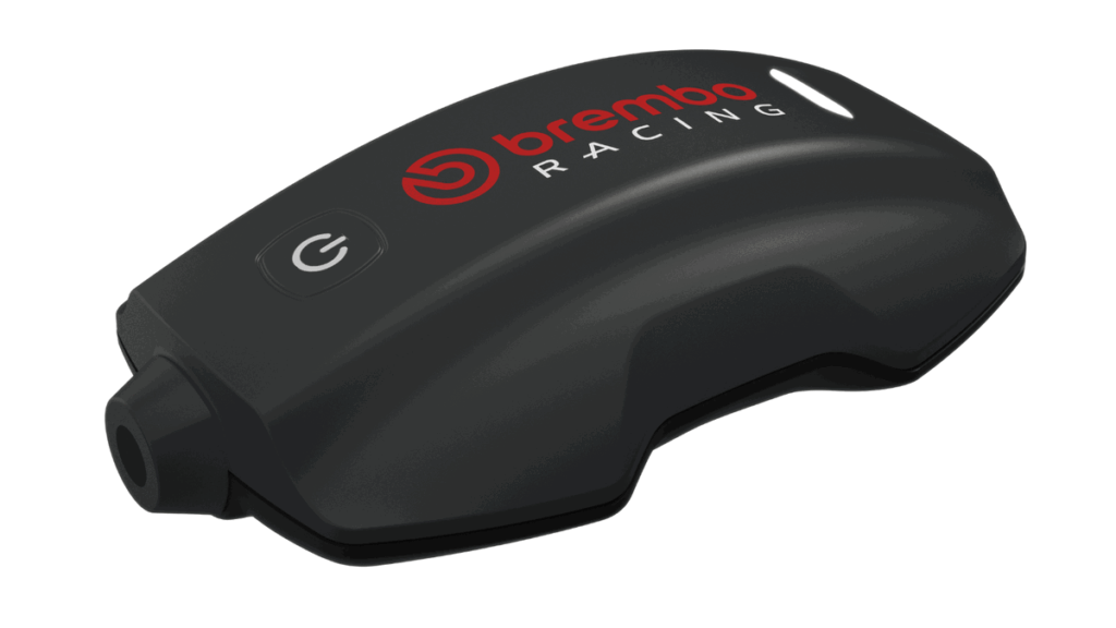 Sistema Brembo TrackTribe sendo exibido, destacando sua interface digital e o prestigioso troféu Red Dot Award, simbolizando a inovação em monitoramento de dados para motociclismo.