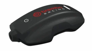 Sistema Brembo TrackTribe sendo exibido, destacando sua interface digital e o prestigioso troféu Red Dot Award, simbolizando a inovação em monitoramento de dados para motociclismo.