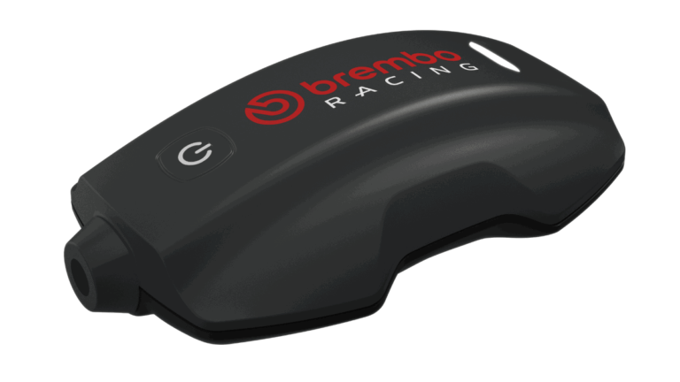 Sistema Brembo TrackTribe sendo exibido, destacando sua interface digital e o prestigioso troféu Red Dot Award, simbolizando a inovação em monitoramento de dados para motociclismo.