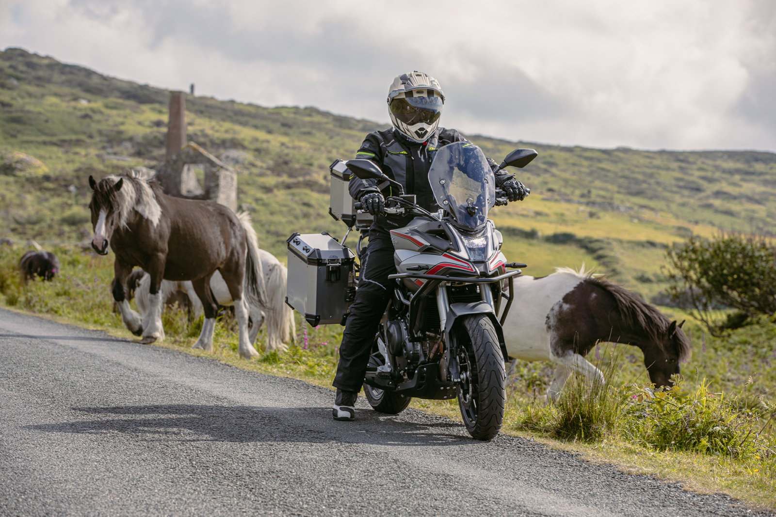 Motocicleta Voge DS 900 X equipada com suspensão Touratech, pronta para aventuras off-road em trilha de terra, demonstrando alta performance e capacidade.