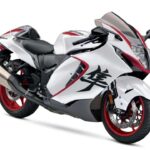 Suzuki Hayabusa 2027 Edição Especial branca e cinza em alta velocidade na estrada, destacando seu design aerodinâmico e esportivo.