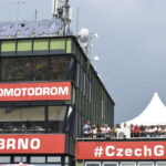Dois pilotos de motociclismo em alta velocidade durante uma corrida FIM no circuito de Brno, República Tcheca, momentos antes de um trágico acidente que resultou em suas mortes.