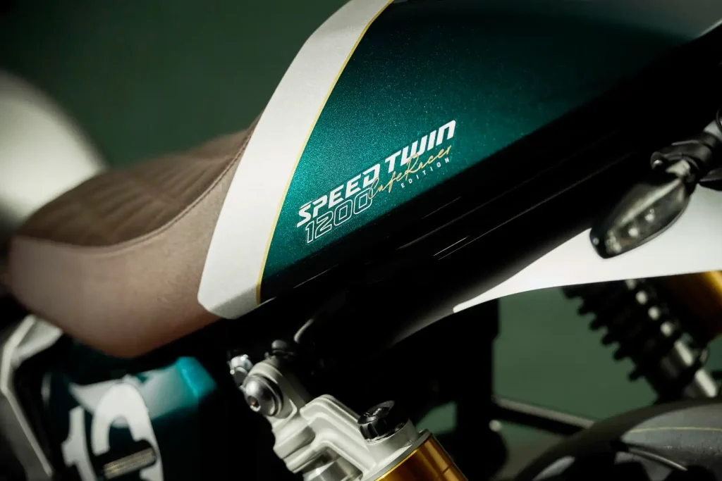 Triumph Speed Twin 1200 Cafe Racer Edition 2027, uma motocicleta clássica moderna com carenagem frontal e estilo retrô em uma estrada europeia, detalhe do farol.
