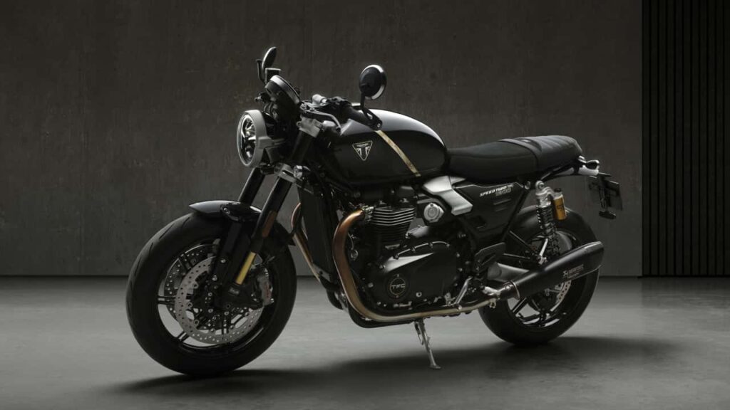 Triumph Speed Twin 1200 TFC, uma motocicleta customizada de fábrica com alta performance, freios Brembo e suspensão Öhlins em uma estrada sinuosa.