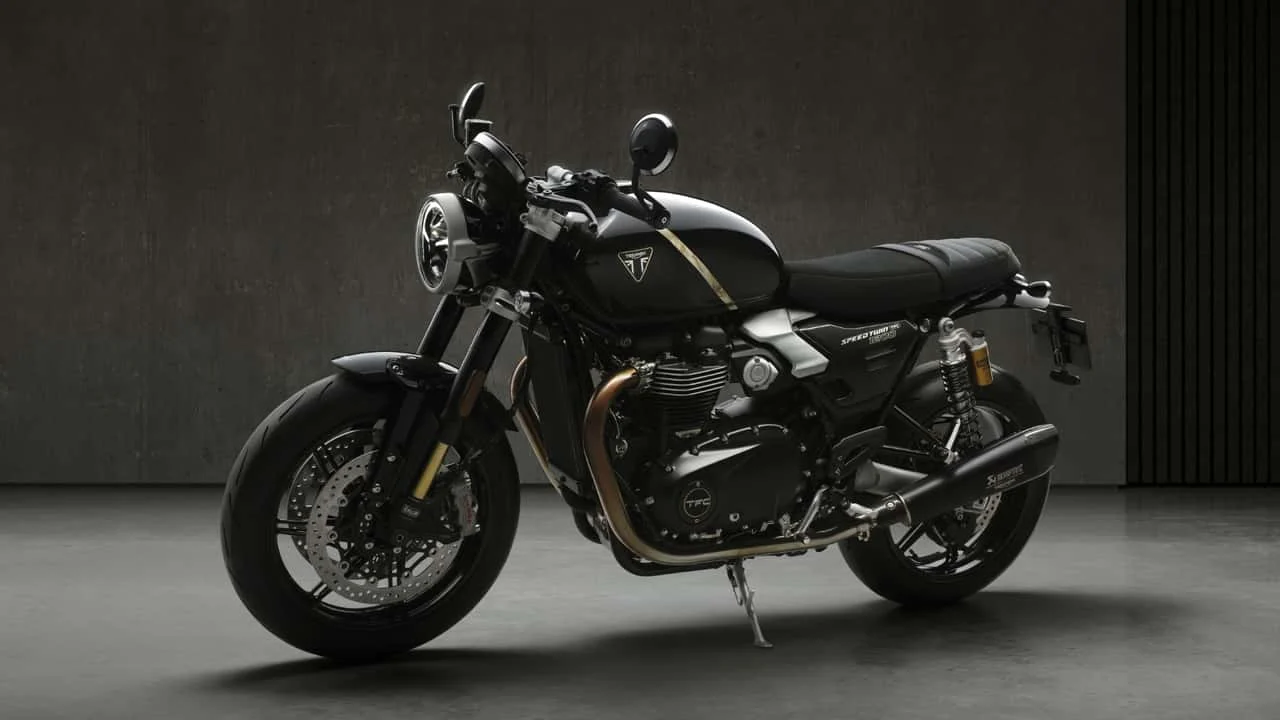Triumph Speed Twin 1200 TFC, uma motocicleta customizada de fábrica com alta performance, freios Brembo e suspensão Öhlins em uma estrada sinuosa.