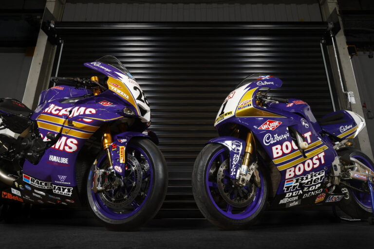 Uma moto de corrida Yamaha YZF-R1 com a icônica pintura roxa e laranja da Cadbury's Boost, pilotada por James Haydon, em alta velocidade na pista do Campeonato Britânico de Superbike (BSB), evocando nostalgia.