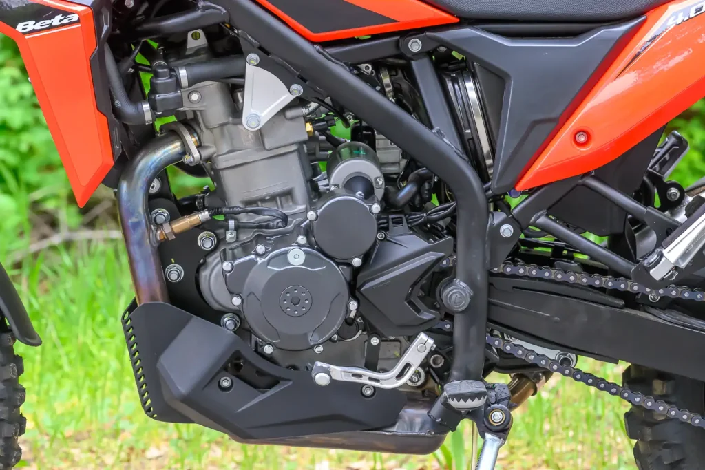 Detalhes da nova motocicleta 2026 Beta Alp 4.0 em trilha de terra com paisagem ao fundo, destacando seu design robusto e pneus de uso misto.