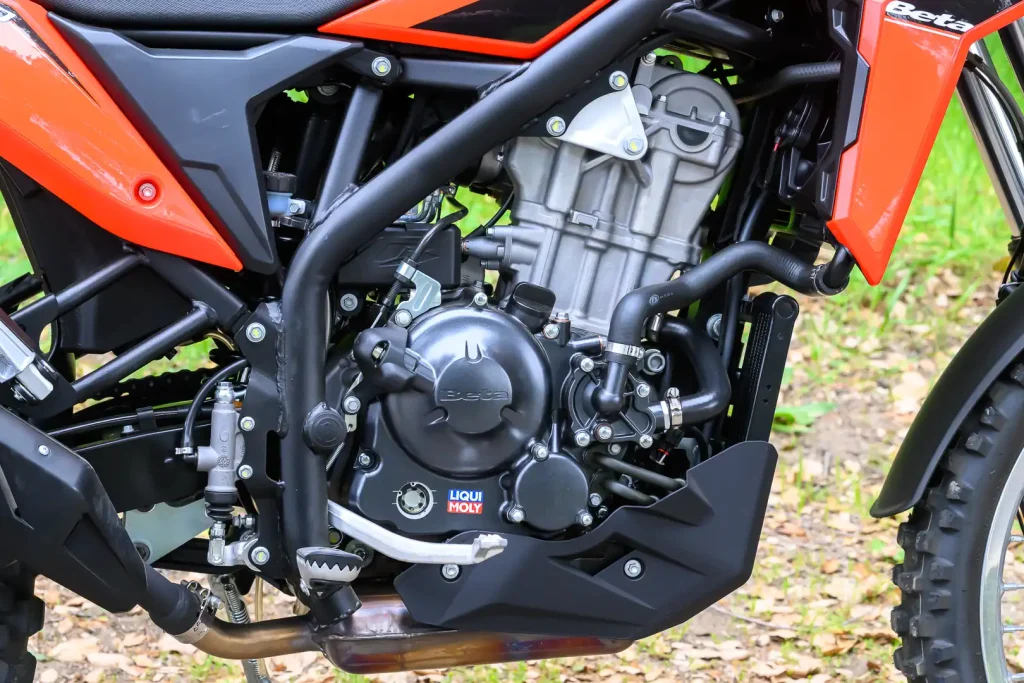 Detalhes da nova motocicleta 2026 Beta Alp 4.0 em trilha de terra com paisagem ao fundo, destacando seu design robusto e pneus de uso misto.