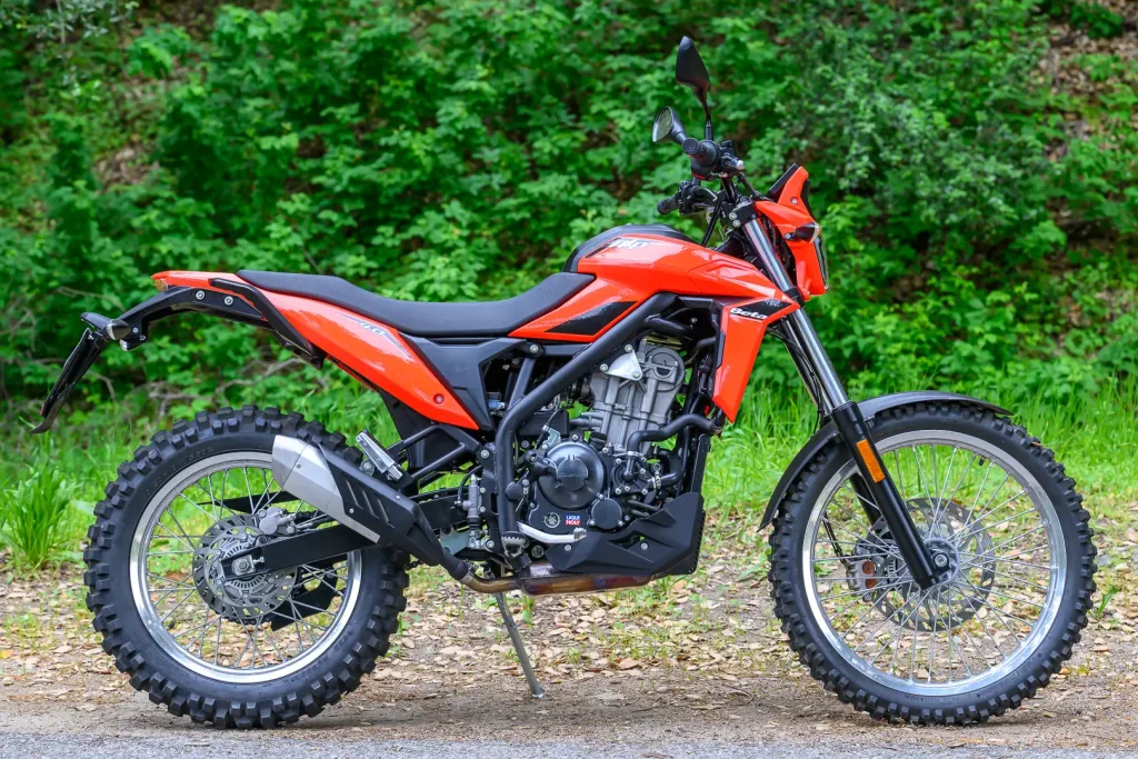 Detalhes da nova motocicleta 2026 Beta Alp 4.0 em trilha de terra com paisagem ao fundo, destacando seu design robusto e pneus de uso misto.