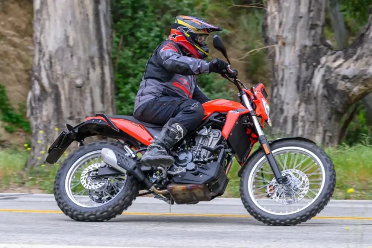 Detalhes da nova motocicleta 2026 Beta Alp 4.0 em trilha de terra com paisagem ao fundo, destacando seu design robusto e pneus de uso misto.