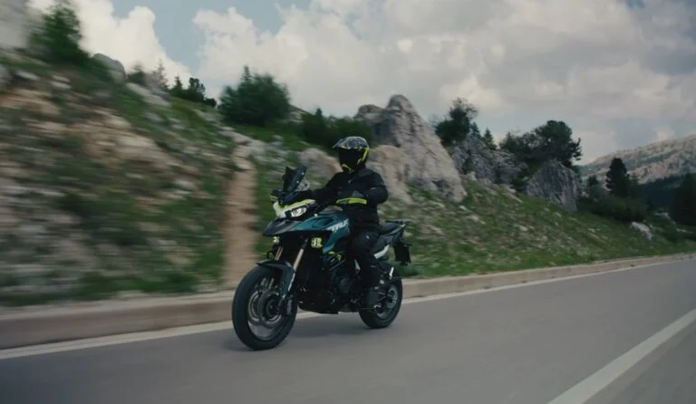 Benelli TRK 902 Xplorer 2024 em destaque, uma bigtrail aventureira com rodas raiadas, grande tanque de combustível e design robusto para off-road.