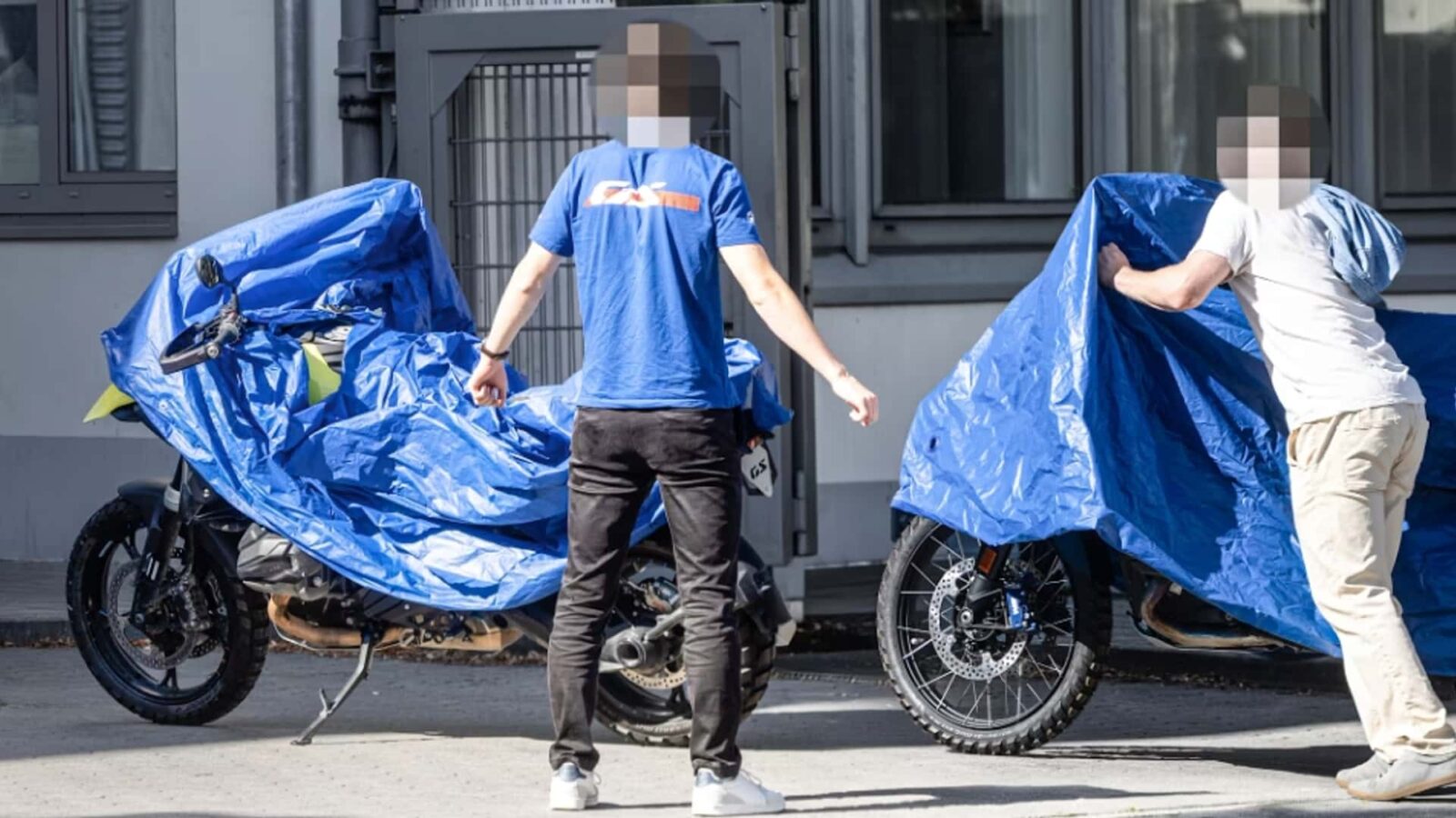 Foto de spy shot da BMW M 1300 GS camuflada em testes, mostrando seu design agressivo e componentes de alta performance em uma estrada de montanha.