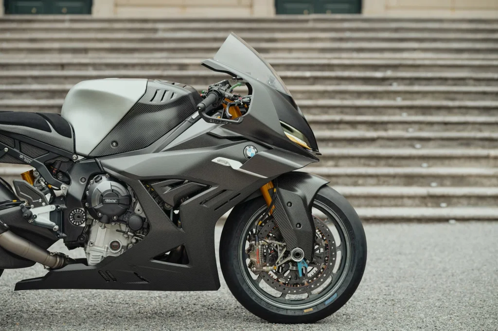 Imagem renderizada da BMW S 1000 RR 2027 em pista, com design inspirado na Concept RR e linhas aerodinâmicas.