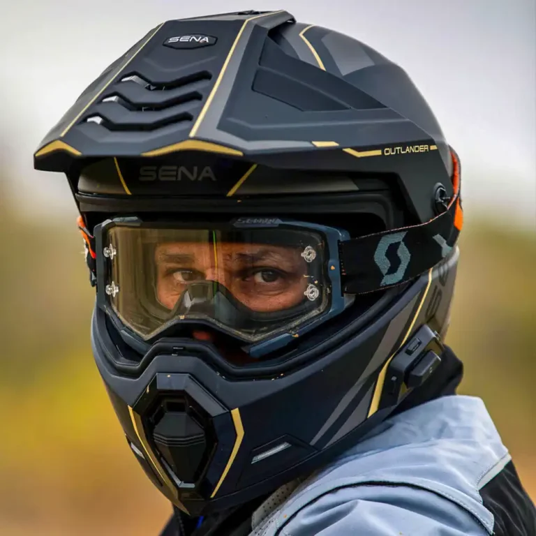 Detalhe do capacete Sena Outlander em acabamento preto fosco, exibindo o sistema de comunicação integrado e as luzes LED traseiras, ideal para motociclistas ADV.