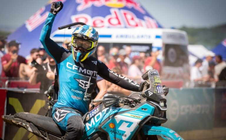 CFMOTO 450MT em ação superando obstáculos extremos em uma trilha de hard enduro na Red Bull Romaniacs, com paisagem montanhosa ao fundo.
