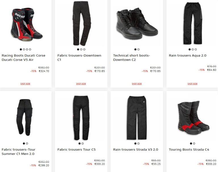 Motociclista vestindo equipamento completo Ducati, incluindo calças e botas, em uma moto esportiva na estrada.