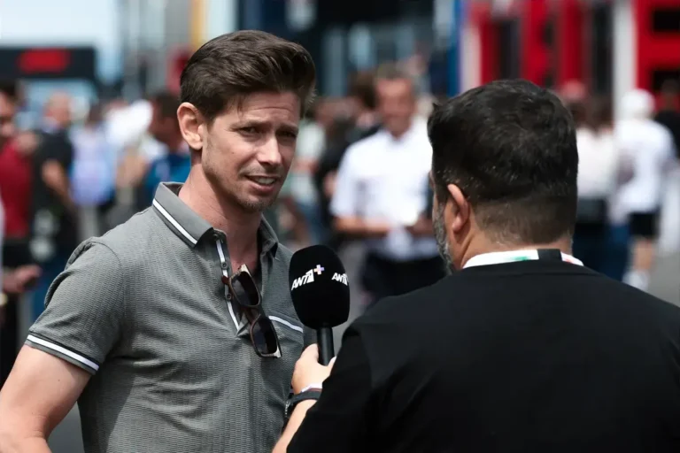 Casey Stoner, piloto australiano bicampeão da MotoGP, olhando para uma moto Ducati, transmitindo sua experiência e autoridade.