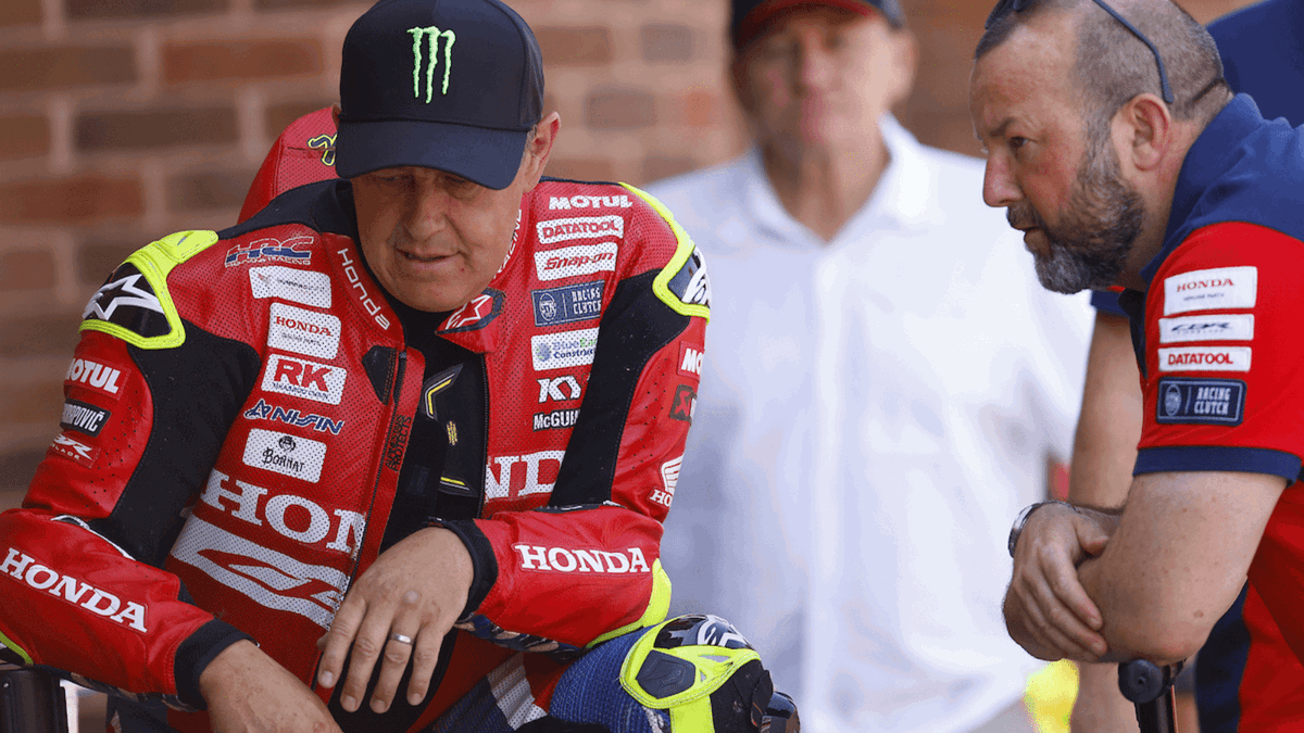 John McGuinness, lenda do motociclismo de estrada, em sua motocicleta Honda durante o Isle of Man TT, demonstrando velocidade e experiência.