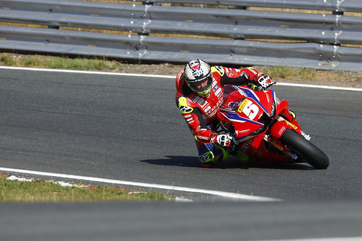 John McGuinness, lenda do motociclismo de estrada, em sua motocicleta Honda durante o Isle of Man TT, demonstrando velocidade e experiência.