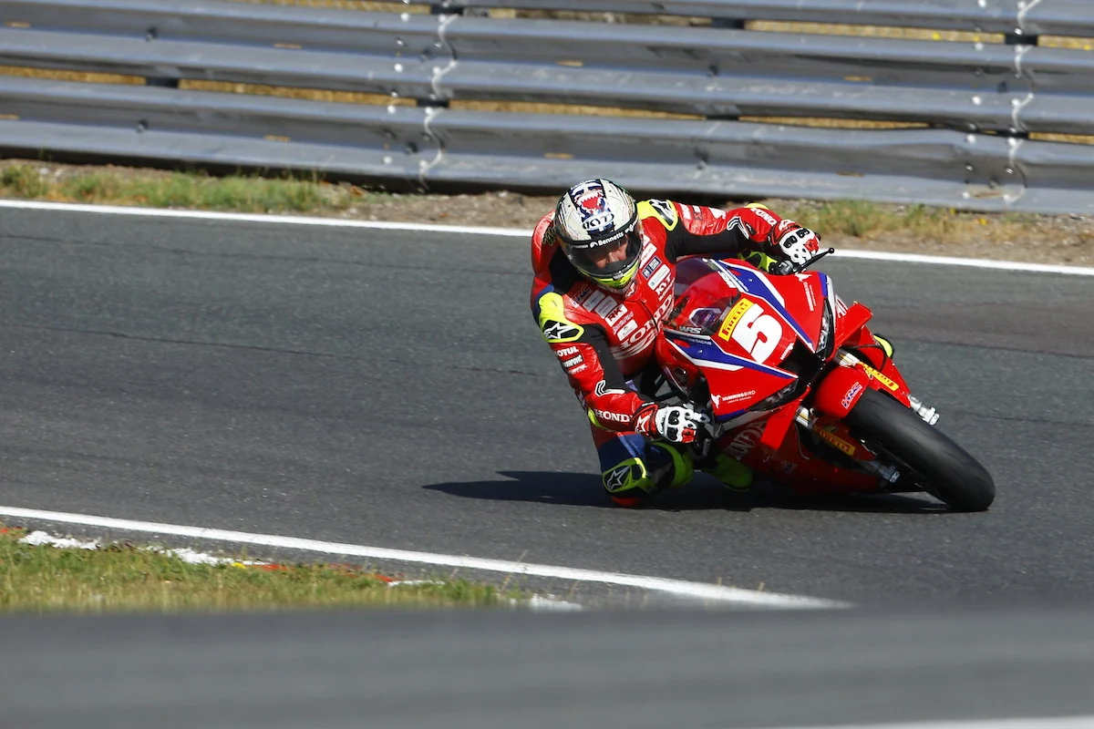 John McGuinness, lenda do motociclismo de estrada, em sua motocicleta Honda durante o Isle of Man TT, demonstrando velocidade e experiência.