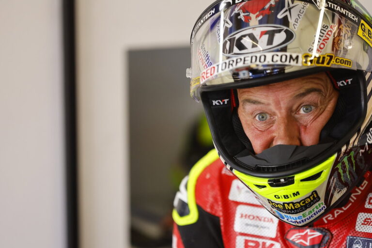 John McGuinness, lenda do motociclismo de estrada, em sua motocicleta Honda durante o Isle of Man TT, demonstrando velocidade e experiência.