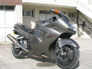 Honda CBR1100XX Super Blackbird em alta velocidade na estrada, destacando seu design aerodinâmico e estilo sport touring dos anos 90.