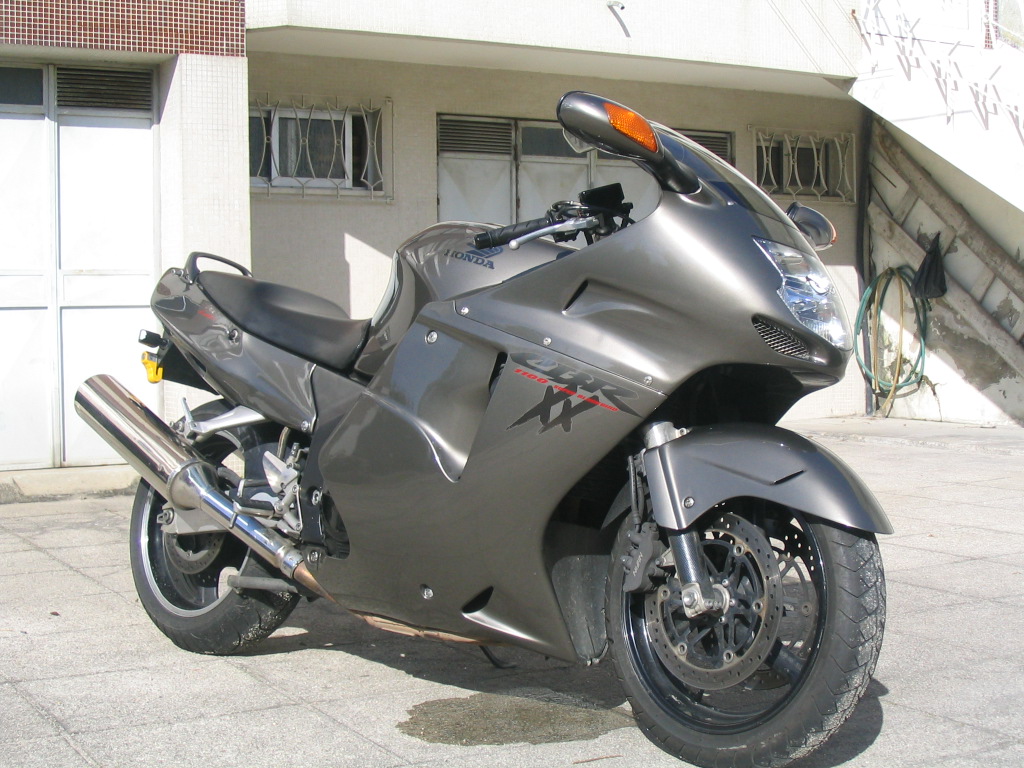 Honda CBR1100XX Super Blackbird em alta velocidade na estrada, destacando seu design aerodinâmico e estilo sport touring dos anos 90.
