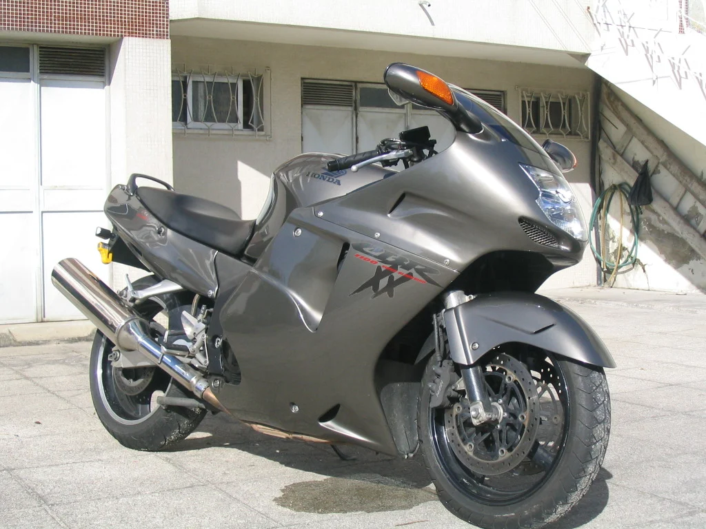 Honda CBR1100XX Super Blackbird em alta velocidade na estrada, destacando seu design aerodinâmico e estilo sport touring dos anos 90.