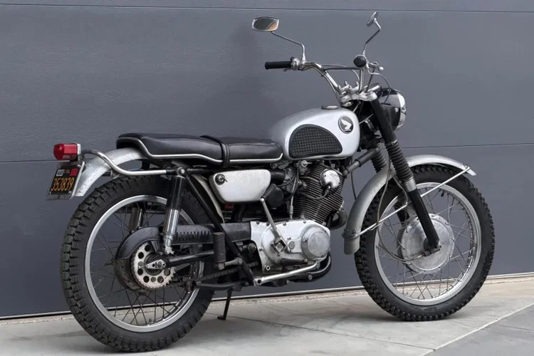 Honda CL72 Scrambler de 1964, modelo associado a Elvis Presley, exibida em leilão com detalhes do seu design clássico e motor. Ilustração da moto no contexto de um evento de leilão de veículos antigos.