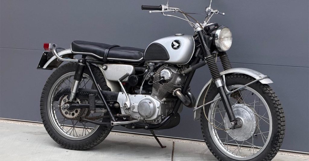 Honda CL72 Scrambler de 1964, modelo associado a Elvis Presley, exibida em leilão com detalhes do seu design clássico e motor. Ilustração da moto no contexto de um evento de leilão de veículos antigos.