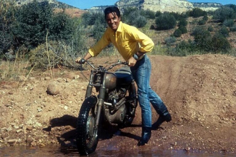 Honda CL72 Scrambler de 1964, modelo associado a Elvis Presley, exibida em leilão com detalhes do seu design clássico e motor. Ilustração da moto no contexto de um evento de leilão de veículos antigos.