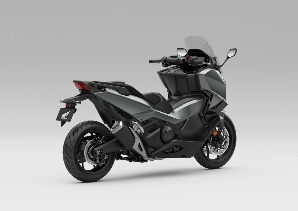 Honda Forza 750 modelo 2027 estacionada em ambiente urbano, exibindo uma das novas opções de cor, destacando seu design sofisticado e linhas esportivas.