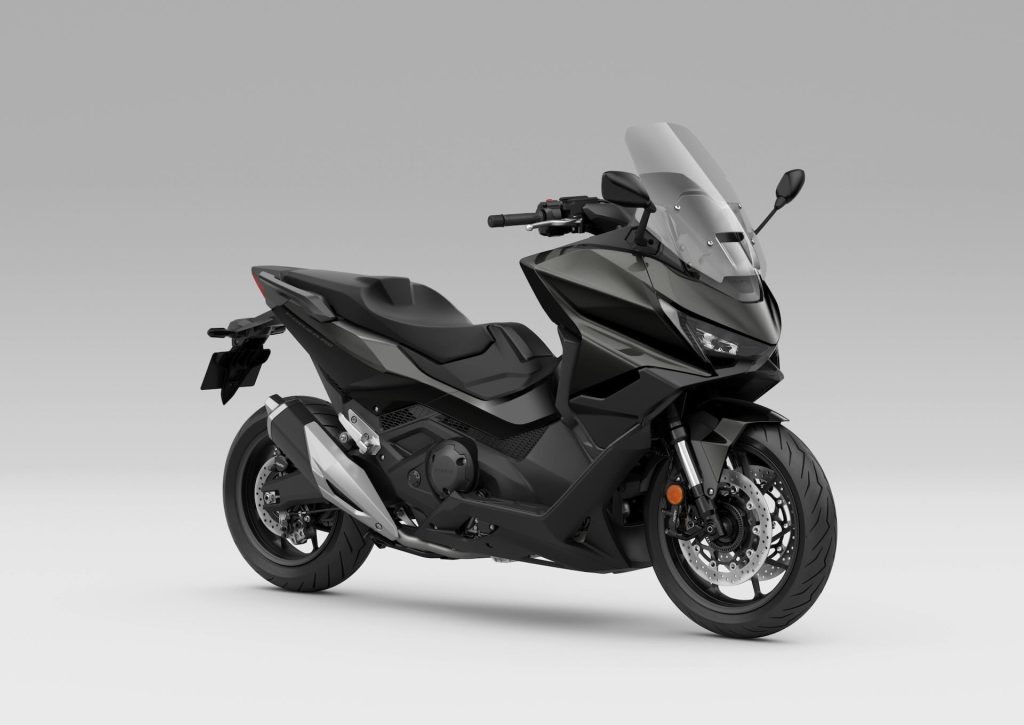 Honda Forza 750 modelo 2027 estacionada em ambiente urbano, exibindo uma das novas opções de cor, destacando seu design sofisticado e linhas esportivas.