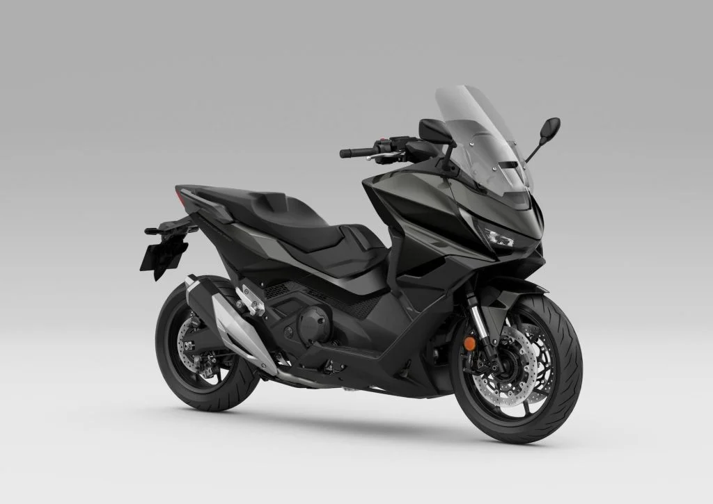 Honda Forza 750 modelo 2027 estacionada em ambiente urbano, exibindo uma das novas opções de cor, destacando seu design sofisticado e linhas esportivas.