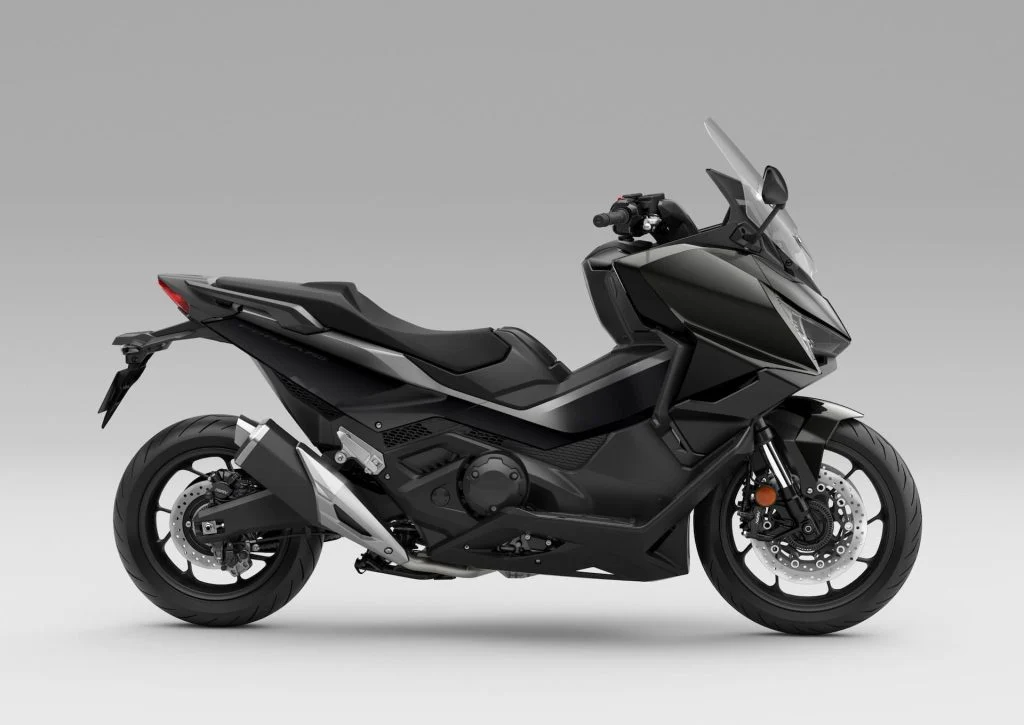 Honda Forza 750 modelo 2027 estacionada em ambiente urbano, exibindo uma das novas opções de cor, destacando seu design sofisticado e linhas esportivas.